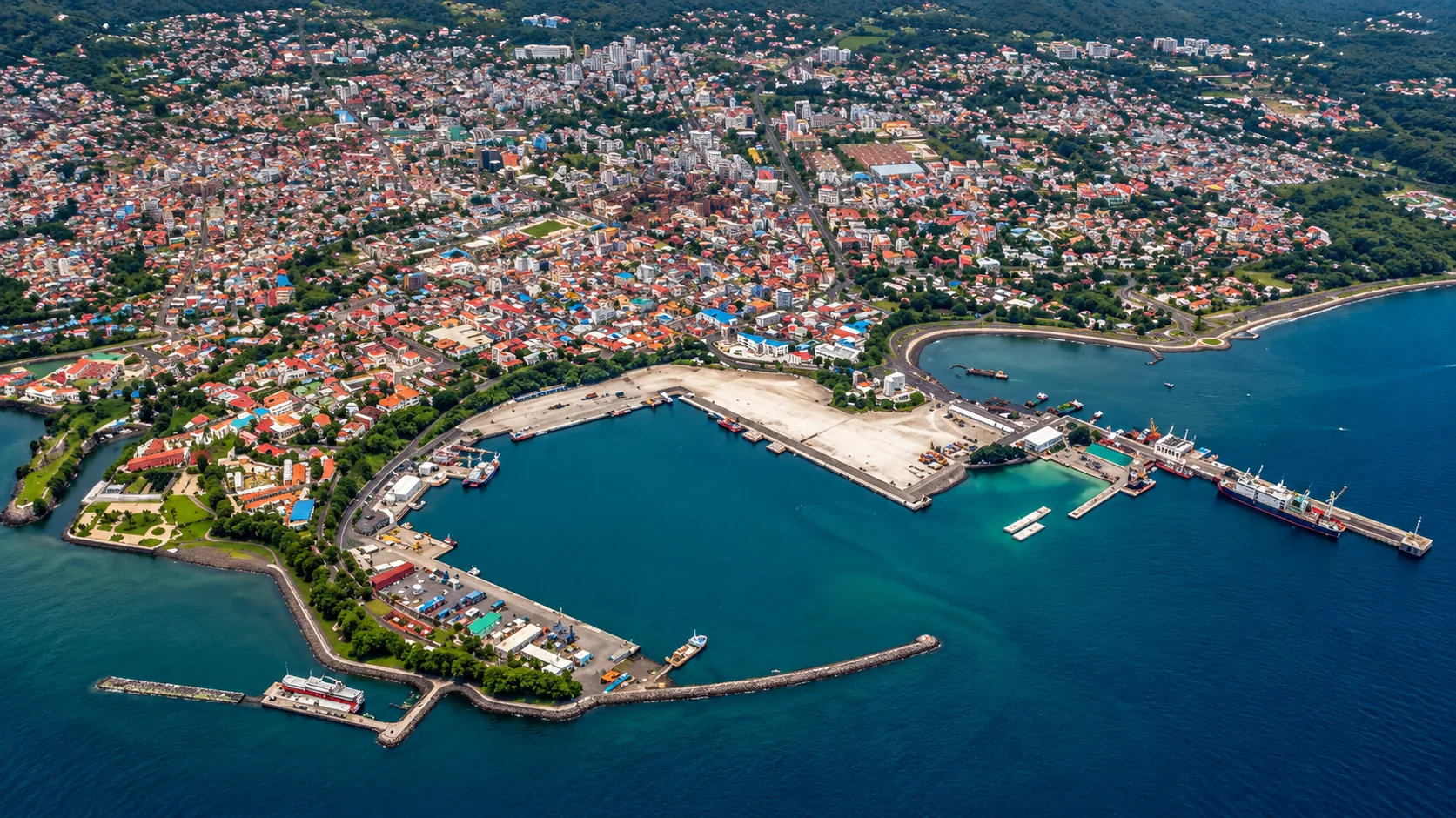 Aerial view of a coastal port city and its harbour, with vessels berthed at the quays
